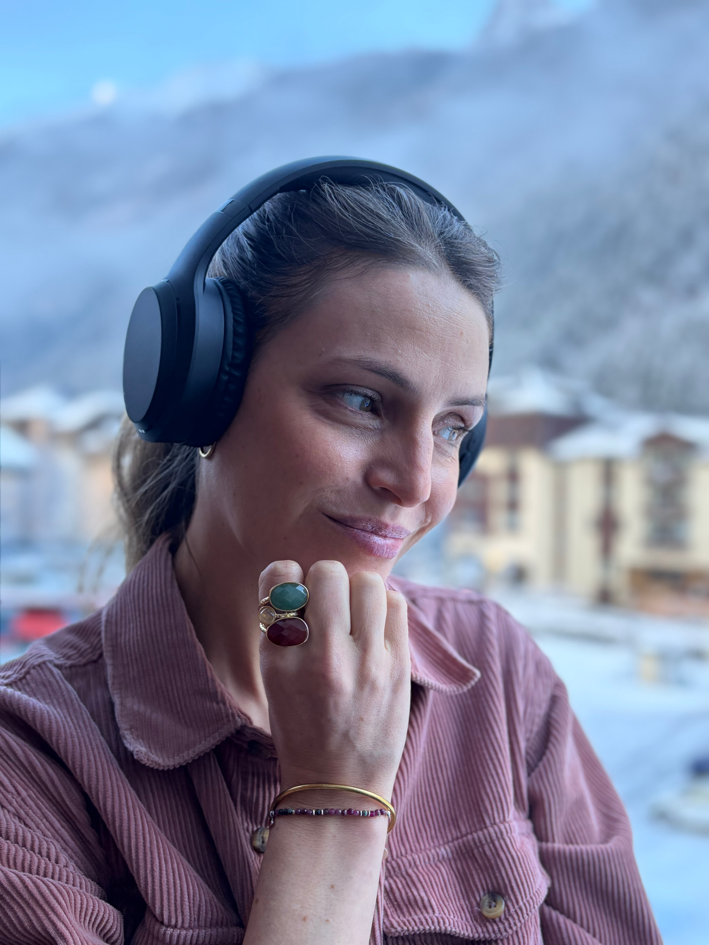 Une personne souriante qui écoute Woodi en plein air, baignée d'une lumière dorée
